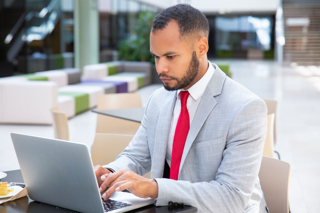 homem sentado mexendo em notebook
